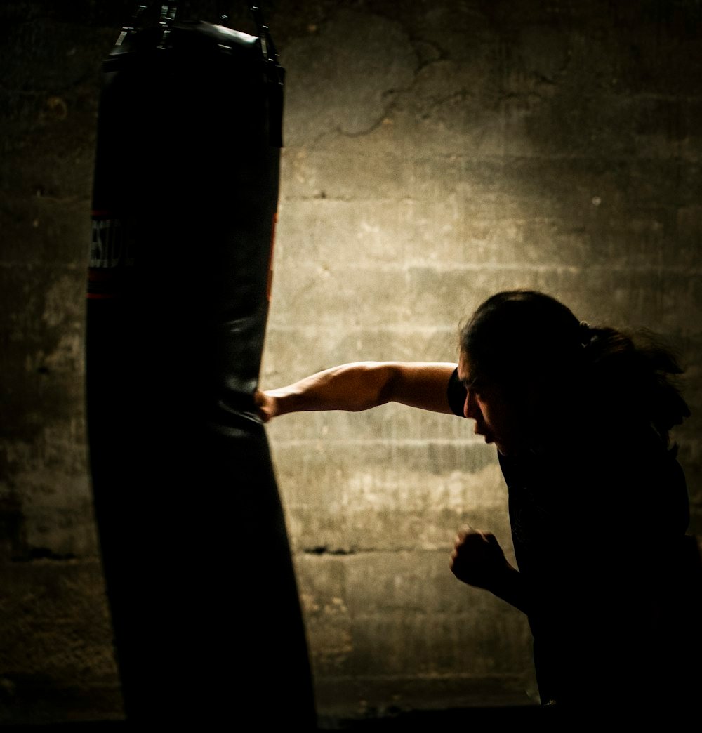 Athlete working a heavy bag in a dark gym